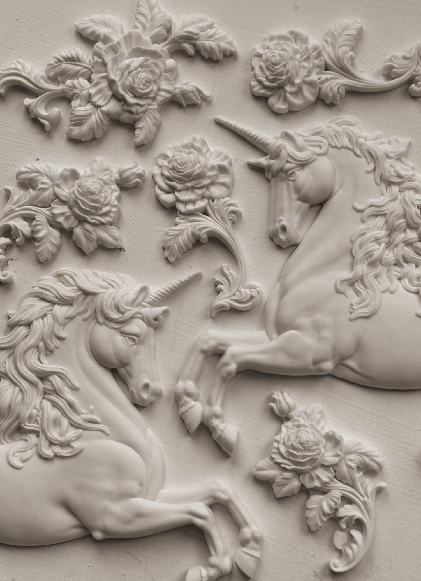 Clay castings of unicorns and flowers attached to the wall, created using the IOD 'Unicorn' Mould.