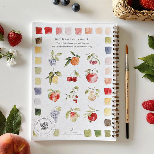 Back Cover of an Emily Lex watercolor workbook titled 'Fruit' with a brush and fruits on a white surface