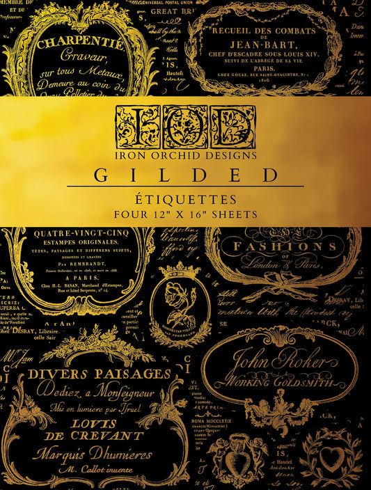 A product image showcasing a sheet of gilded iron-on-transfer (IOD) designs named 'Etiquettes Gilded' which features intricate floral and typographic patterns in a gold color on a black background.