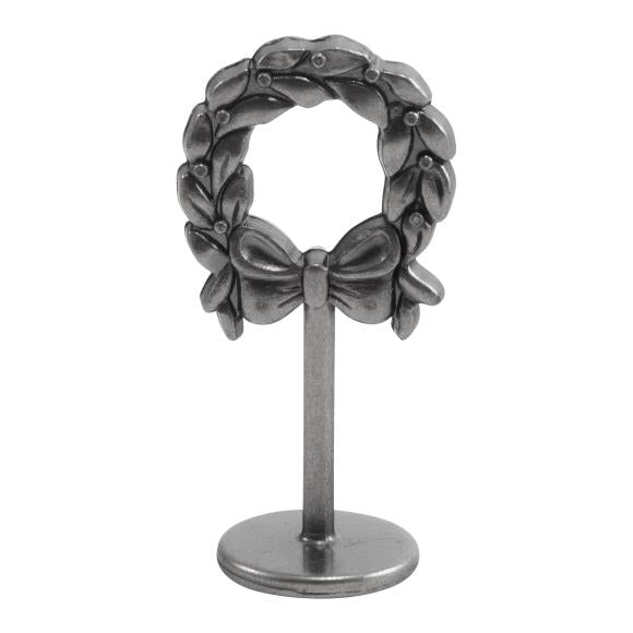 Decorative miniature Tim wreath with a bow on a stand against a white background