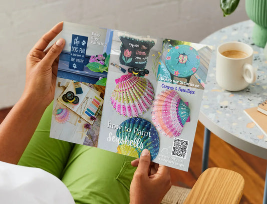 Person holding a craft book with colorful illustrations on a casual setting