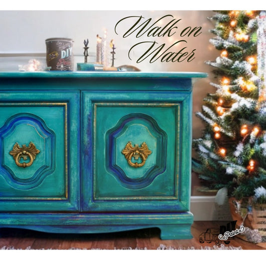 A cabinet painted with DIY Paint color "Walk on Water", with a can of paint and brush sitting on top.