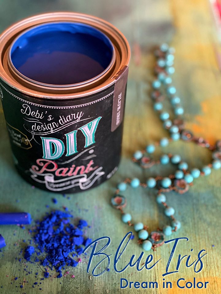 Can of open Blue Iris paint from DIY brand, with blue pigment dust in front of can to show off color