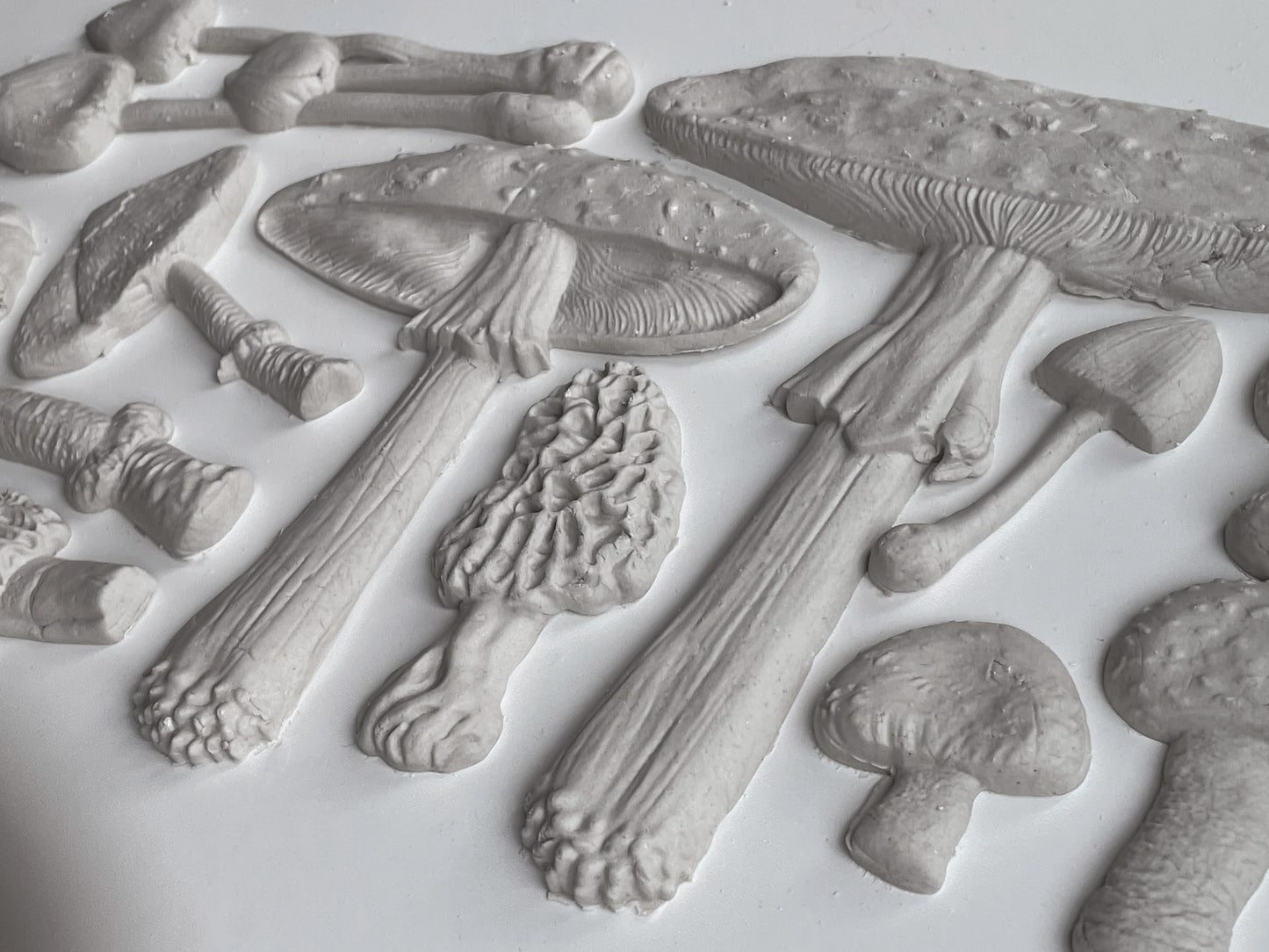 Clay castings of mushrooms from the IOD "Toadstool" mould, sitting on a white table.