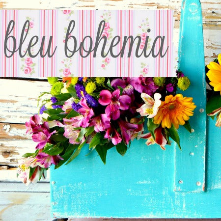 A teal tote painted in the milk paint color "Bleu Bohemia", holding flowers.
