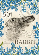 A decoupage paper of a rabbit stamp surrounded by blue spring flowers and 50 cents in the corner.