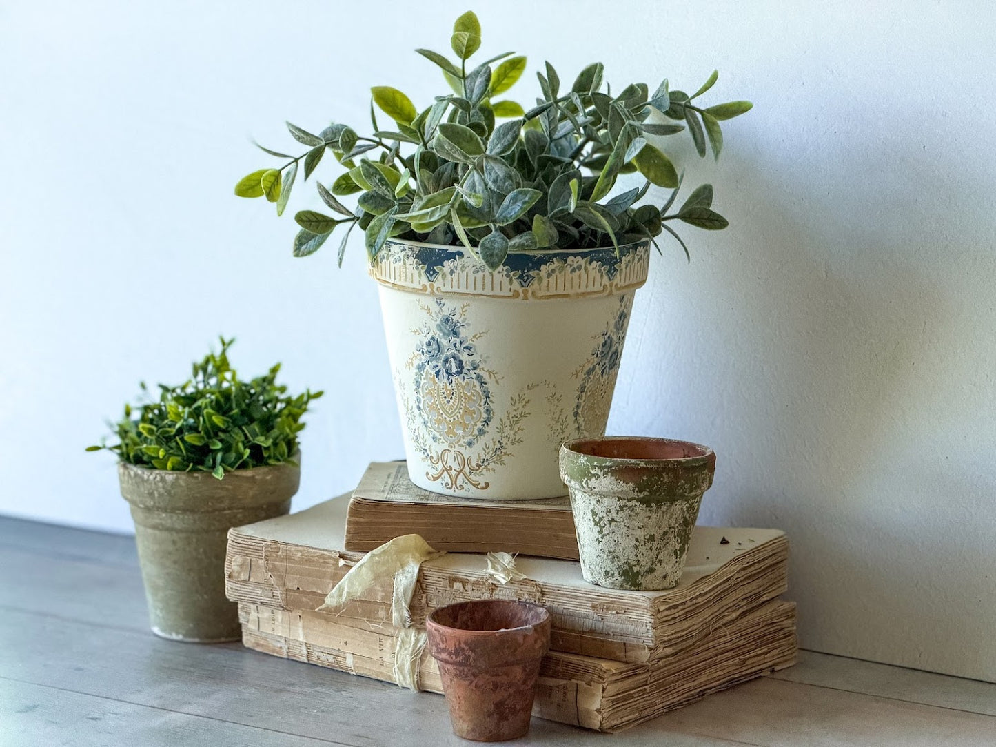 Decorative arrangement of plants in pots that have paint inlays on them.