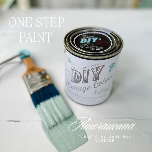 A can of DIY Cottage Color furniture paint in the shade 'Ameraucana' with a built-in topcoat, displayed alongside a paintbrush on a painted surface.