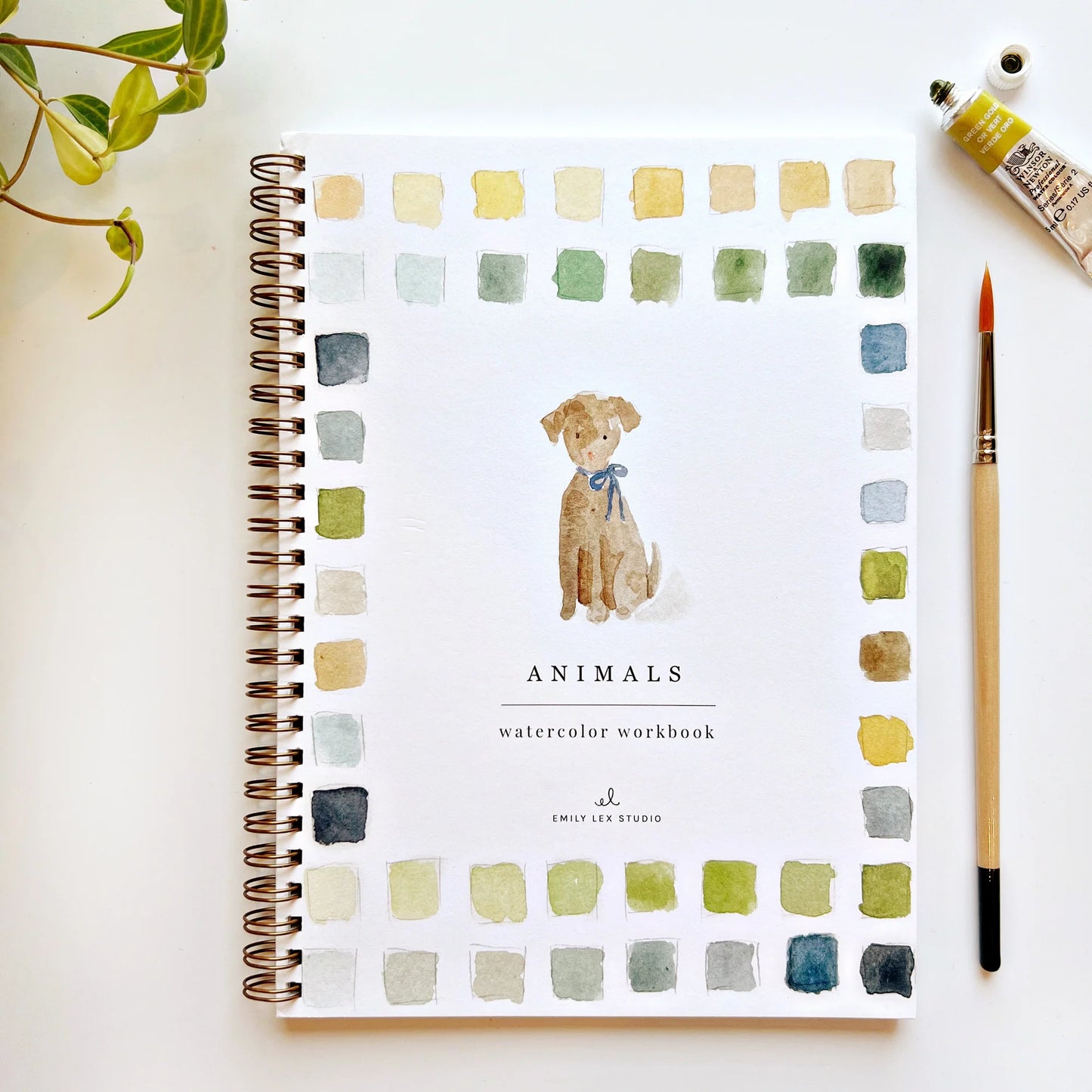 Cover of the 'Animals Watercolor Workbook' by Emily Lex Studio featuring a watercolor illustration of a dog with a bow, surrounded by color swatches and a paintbrush.