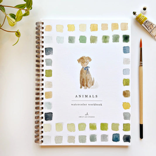 Cover of the 'Animals Watercolor Workbook' by Emily Lex Studio featuring a watercolor illustration of a dog with a bow, surrounded by color swatches and a paintbrush.
