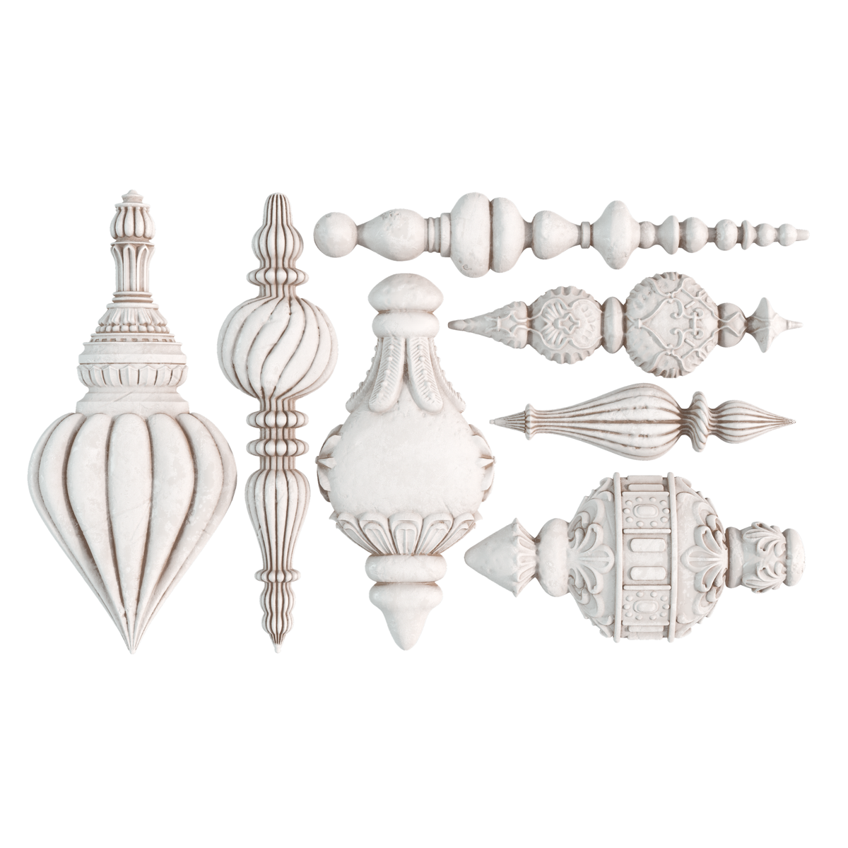 A set of ornate white clay castings arranged on a plain white background, including pointed, ribbed, fluted, and carved ornament styles.
