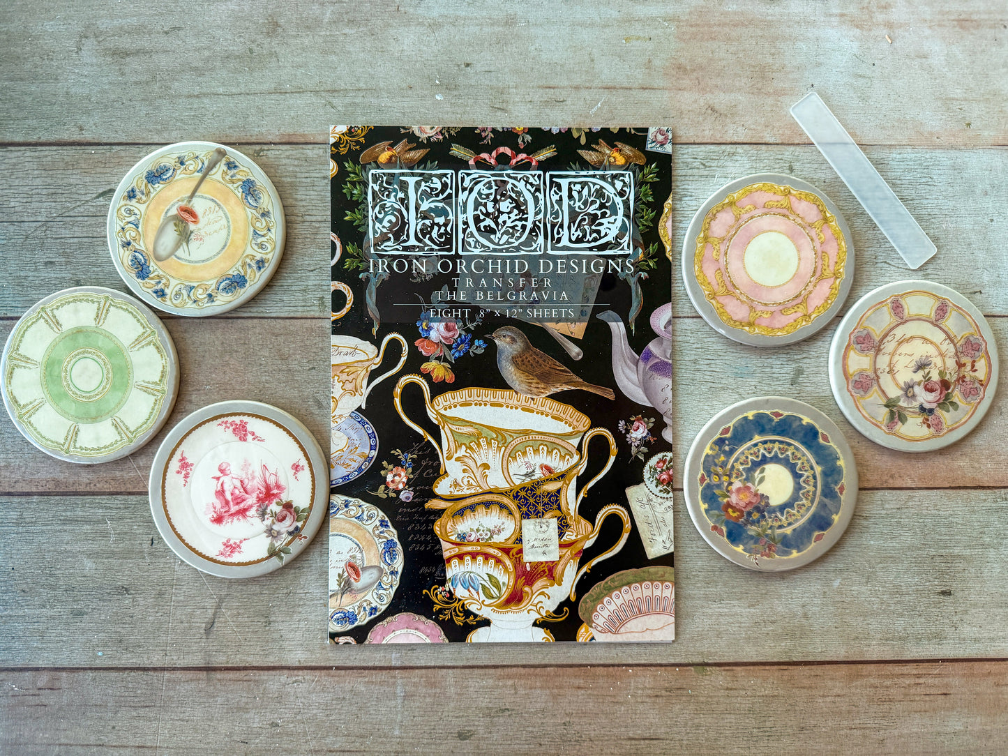 Decorative plates with floral designs on a wooden surface, featuring a transfer pad titled 'Belgravia'.