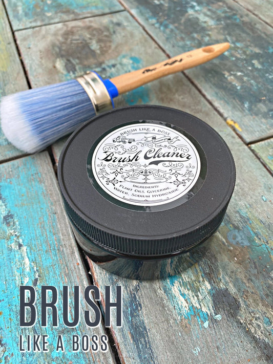 Brush cleaner container with brush on a wooden surface, featuring 'Brush Like a Boss' text.