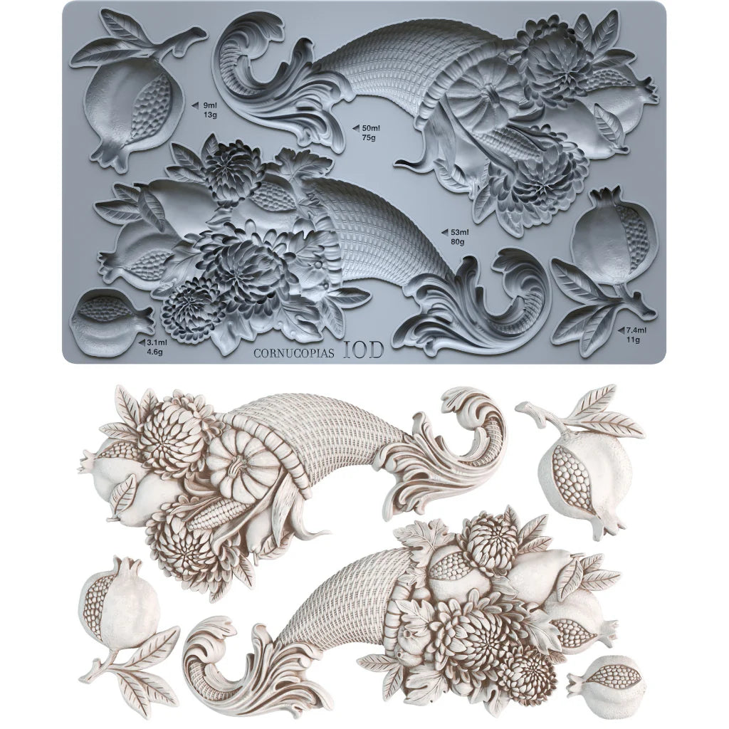 An IOD cornucopia mold shown in gray with its corresponding white 3D molded sample, featuring detailed floral, leaf, and pomegranate motifs on a white background.