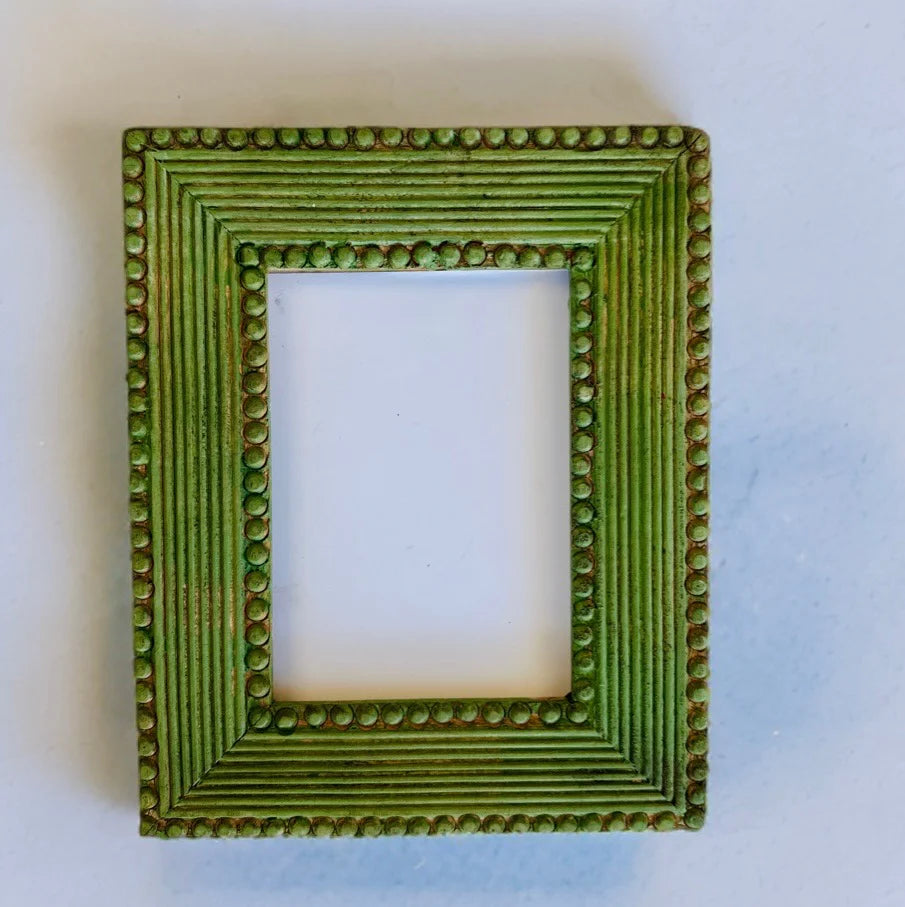 A picture frame painted in a "Garden Sage" green color, showcasing a DIY paint application.