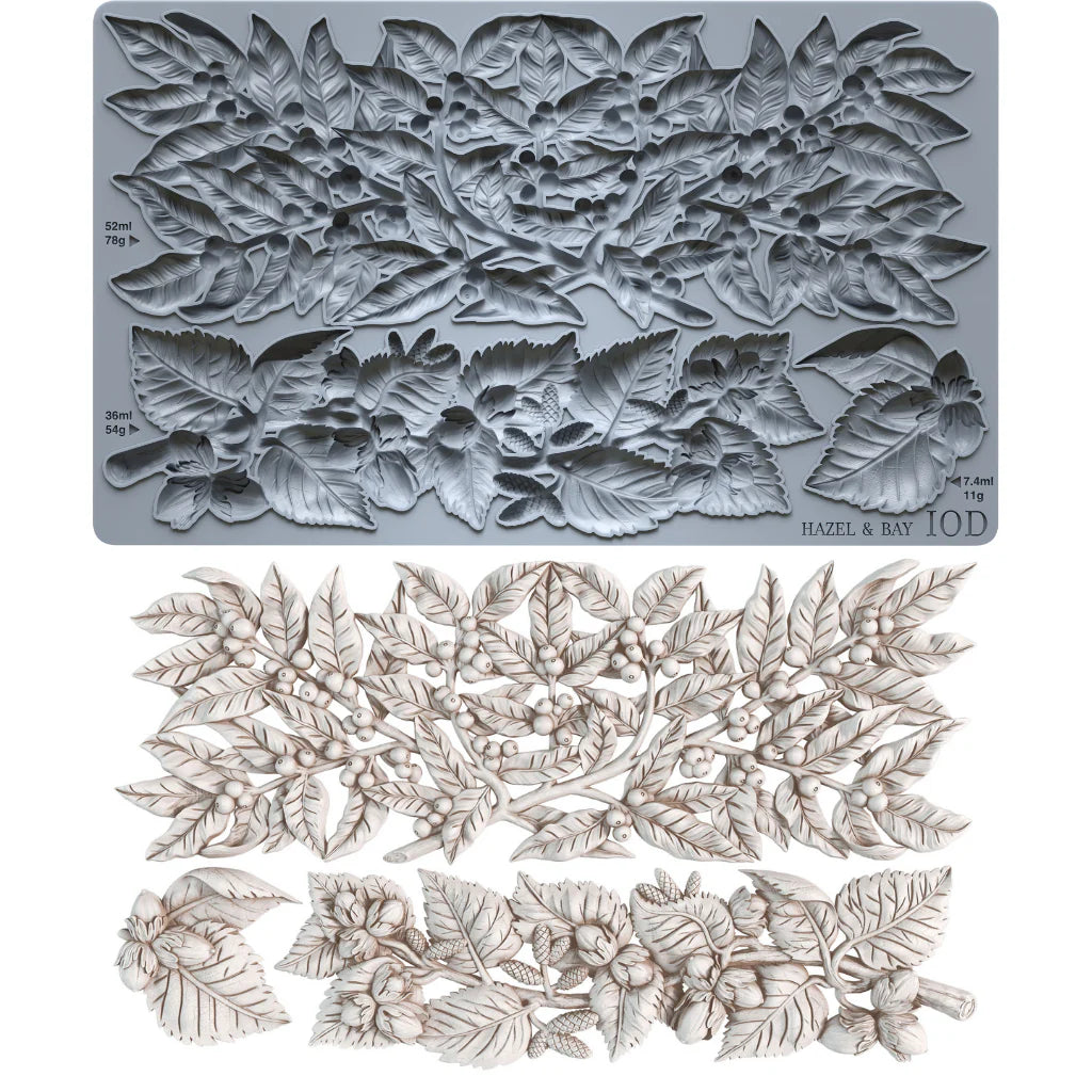 A bayleaf and holly mould, shown above a matching set ofcastings of leaf and berry cutouts in an off-white tone. Small printed markings on the plate include 'HAZEL & BAY' and '10D'.