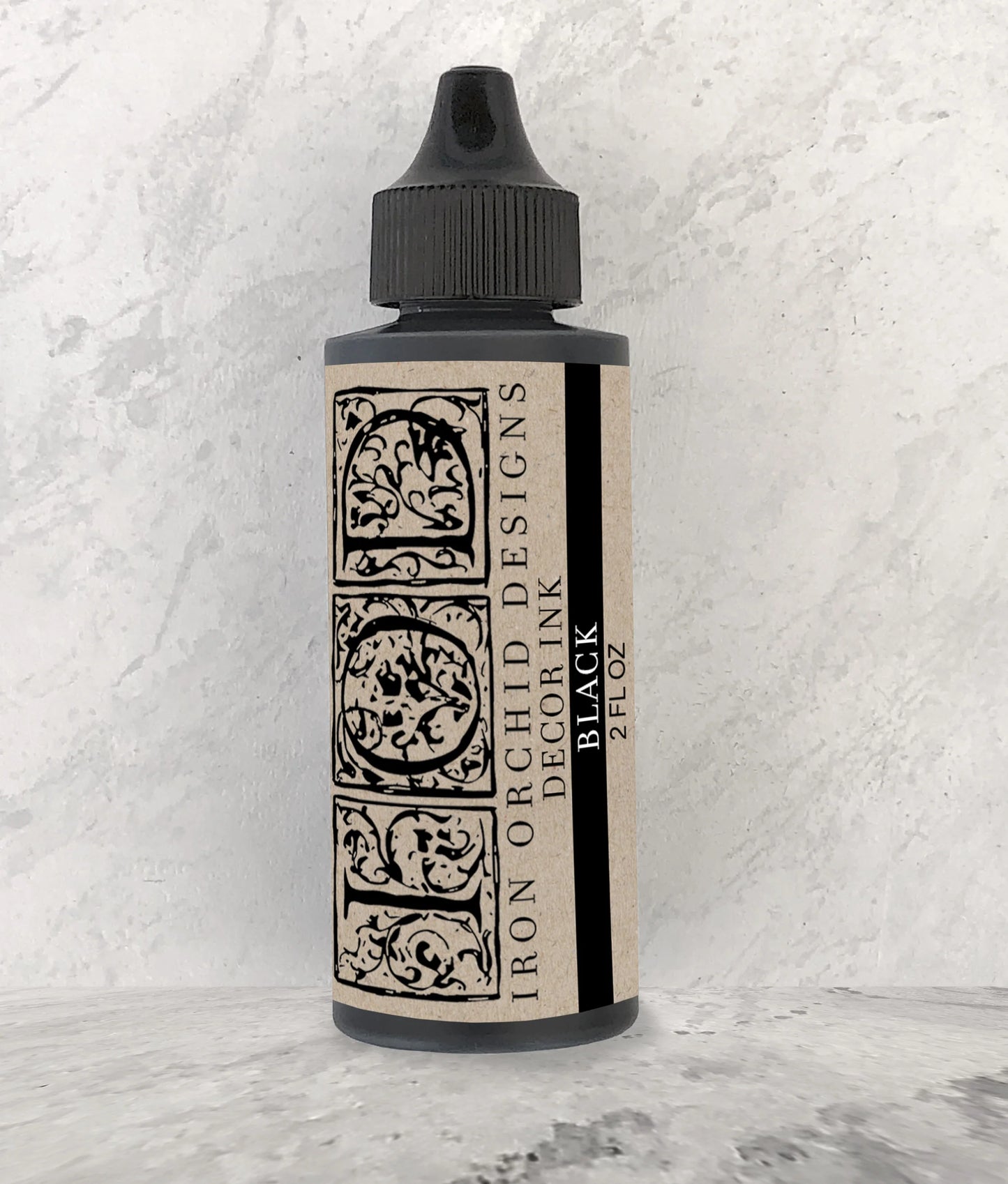 Bottle of black decor ink with decorative label on a textured white background