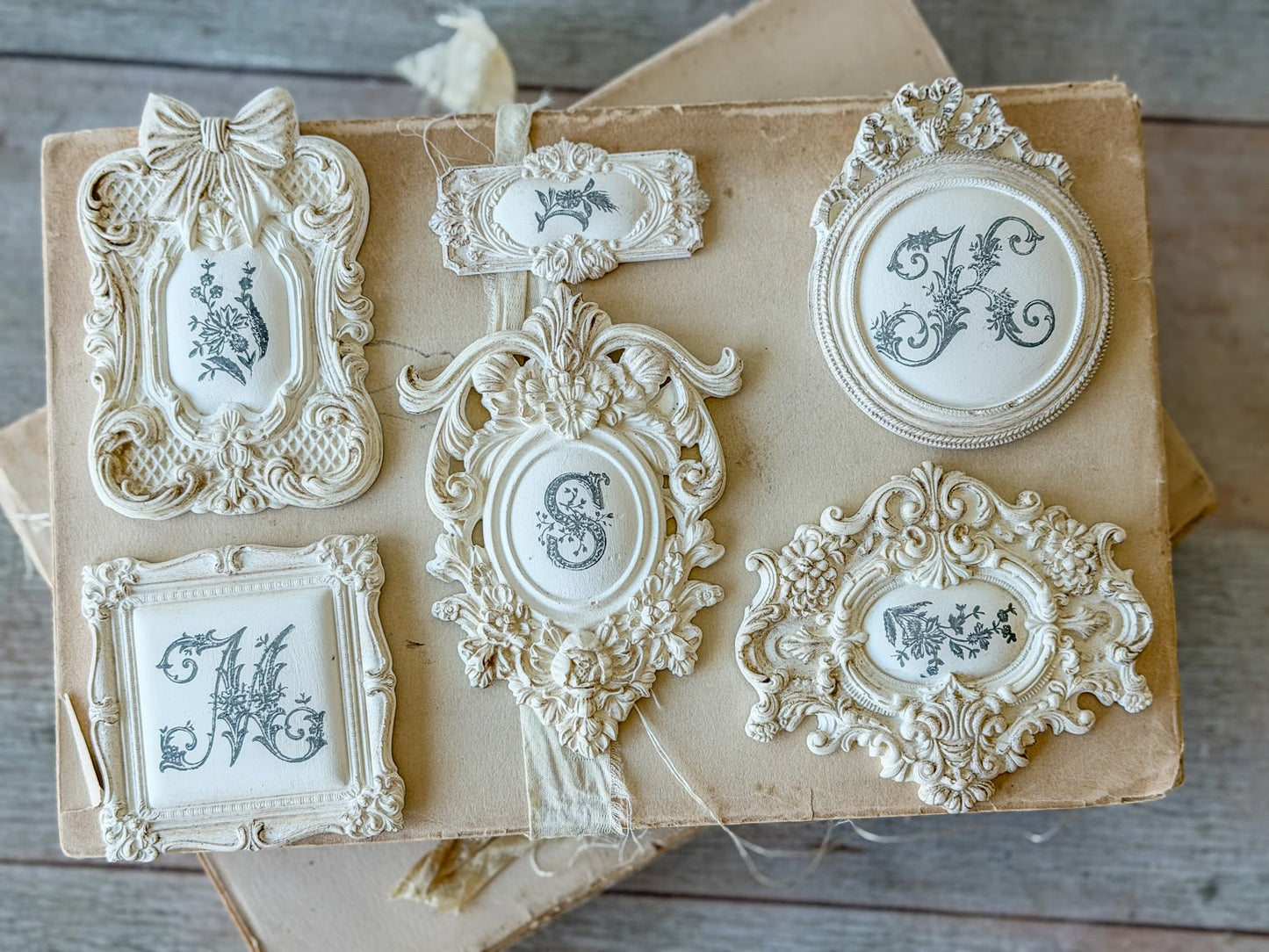 6 example frame castings stamped with monogram letters.