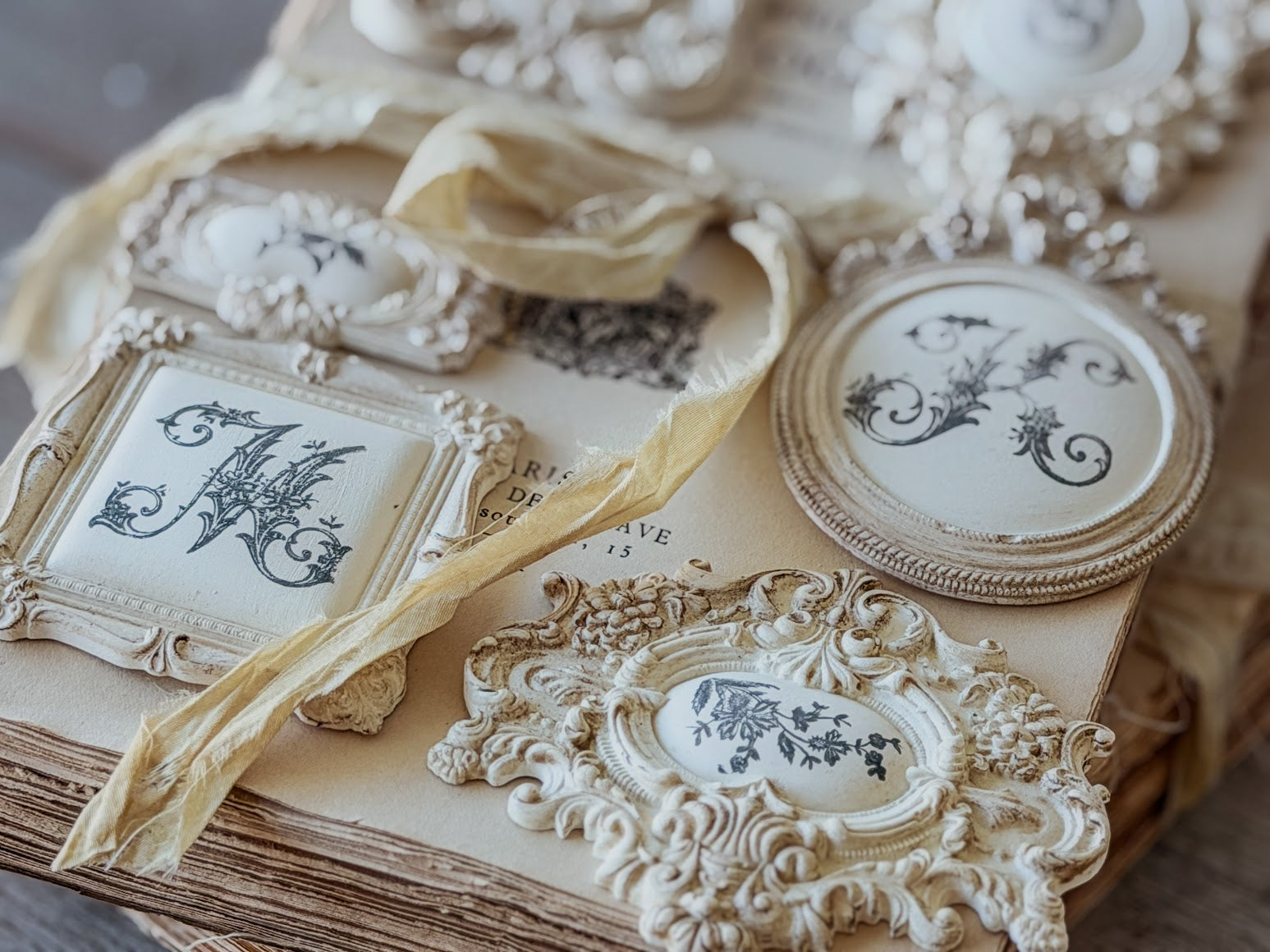 Decorative frames set with ornate castings, all sitting on a vintage book.