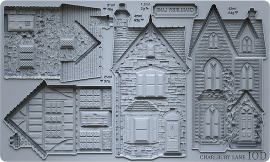 A gray silicone mould featuring detailed embossed house designs and architectural sections, with a printed label including 'CHARLBURY LANE'.