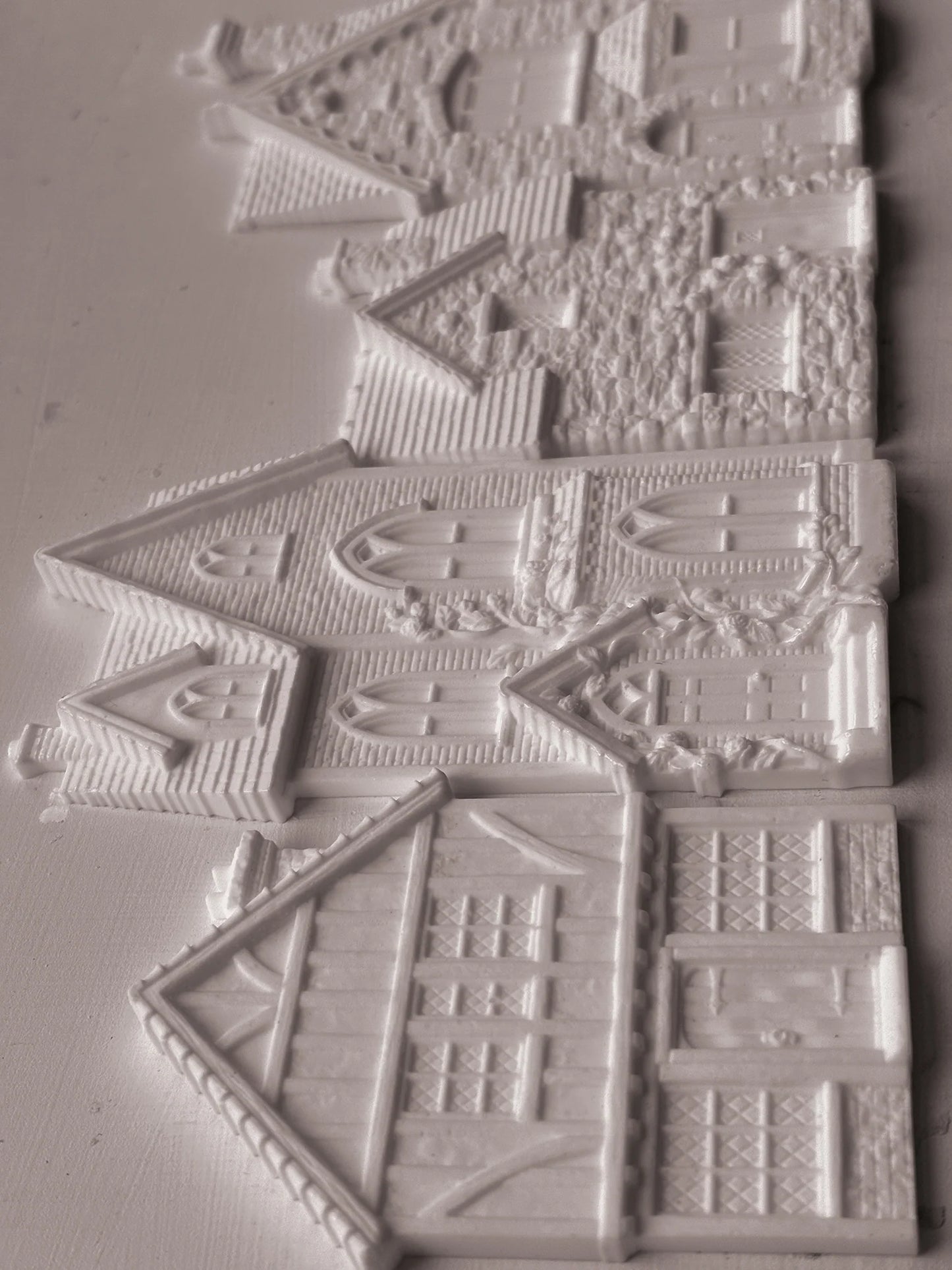 White resin decorative pieces shaped like houses and cottages, shown on a plain light background.