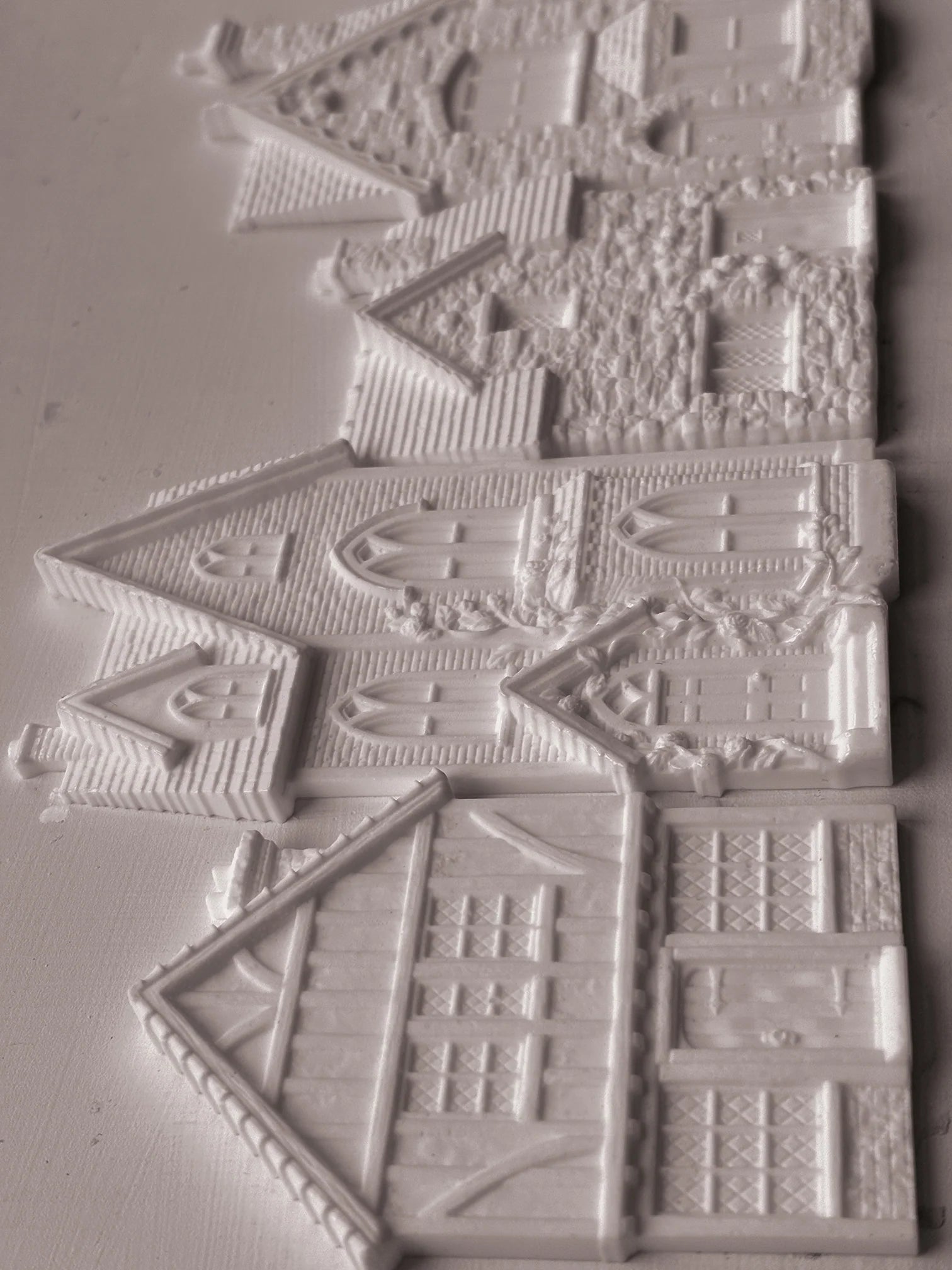 White resin decorative pieces shaped like houses and cottages, shown on a plain light background.