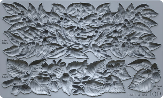 A gray silicone mould featuring a detailed relief pattern of hazelnuts, leaves, and berries, with printed dimensions and the brand name 'HAZEL & BAY' visible in the bottom right corner.