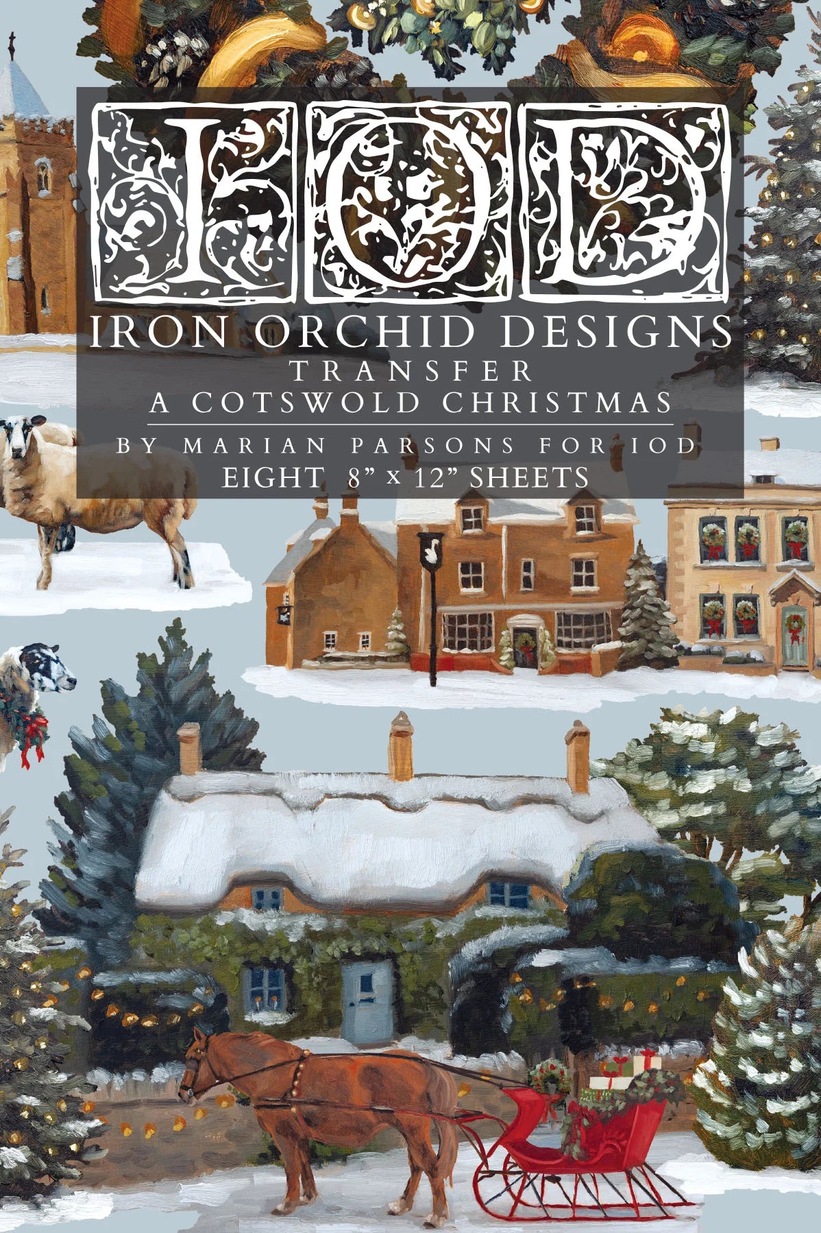 Cover of Transfer: 'A Cotswold Christmas' by Marian Parsons, featuring an illustrated winter village scene with snow-covered cottages, evergreen trees, a horse-drawn sleigh, and a large decorative 'IOD' monogram at the top.