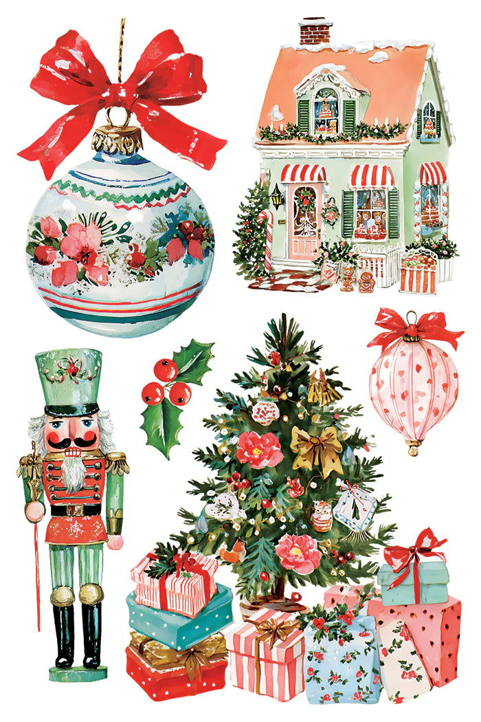 A transfer sheet of Christmas-themed illustrations on a white background, including a large ornament with a red bow, a decorated house, a nutcracker, a Christmas tree with gifts, and a pink patterned hot air balloon.