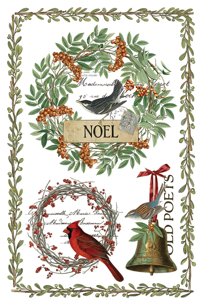 A rub-on transfer sheet with vintage-style Christmas art print featuring two wreaths with birds, a green leaf border, a hanging brass bell with a red ribbon, cursive script, and the word 'NOEL' on a wooden plaque.