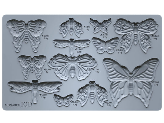 A gray, butterfly-shaped silicone mold with measurements on a white background.