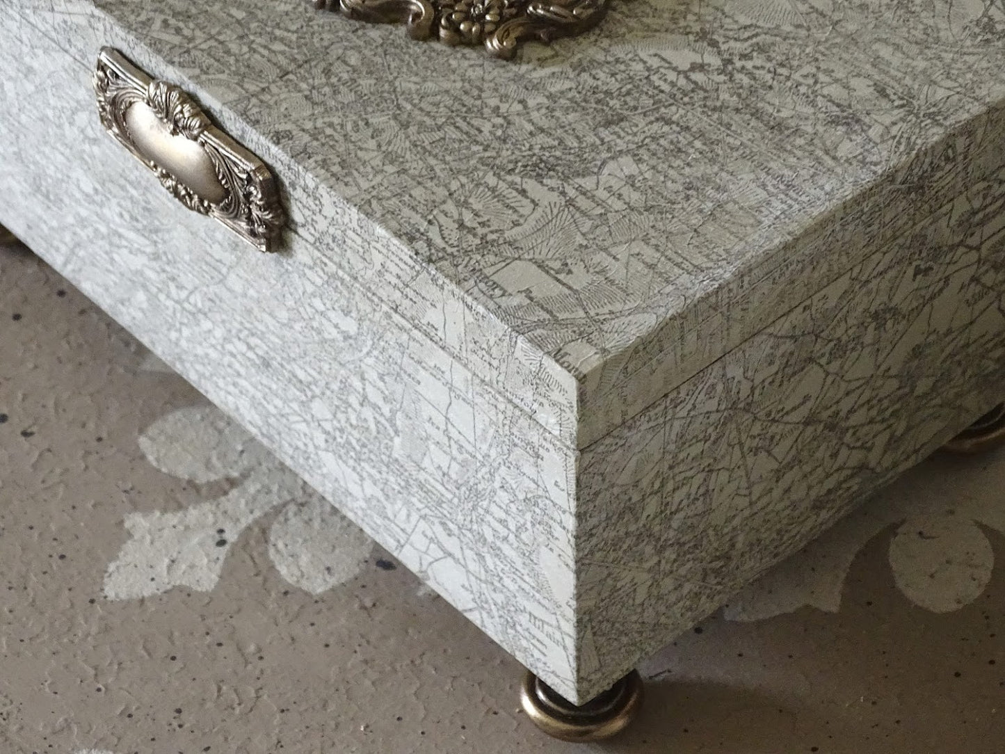 Side angle of white box stamped with a map pattern from the Orléans IOD stamp.