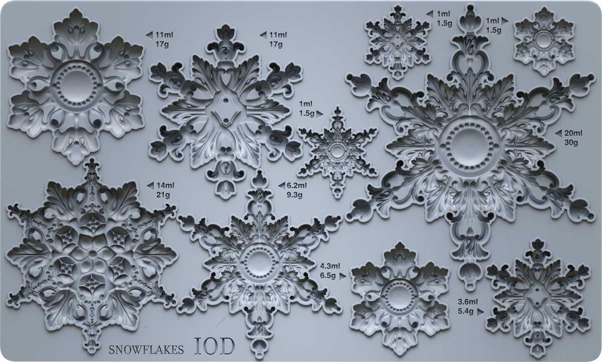 A gray silicone mold tray featuring multiple ornate snowflake designs of varying sizes, each labeled with its volume in milliliters and weight in grams. The bottom left corner displays the text 'SNOWFLAKES IOD'.