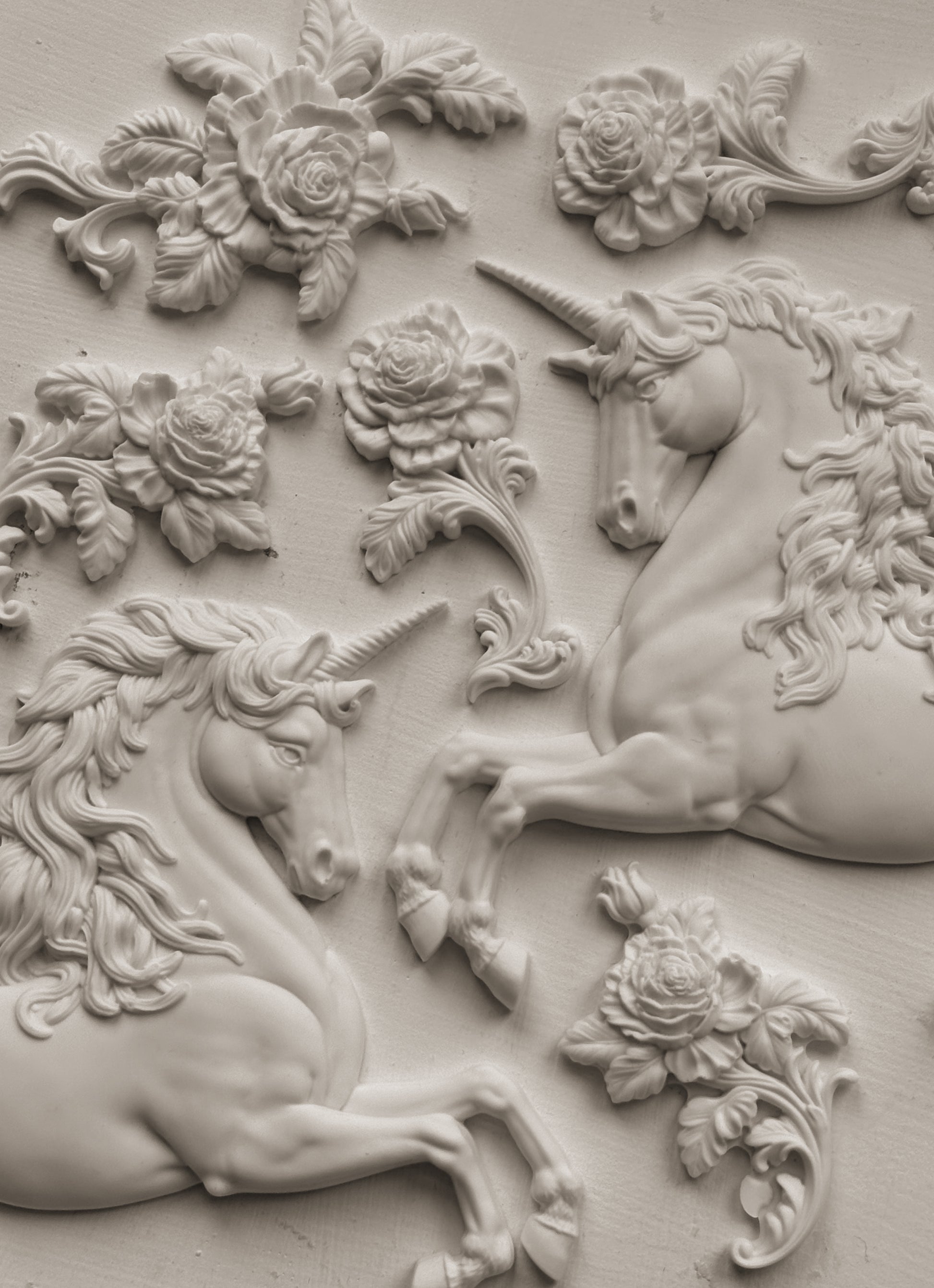 Clay castings of unicorns and flowers attached to the wall, created using the IOD 'Unicorn' Mould.