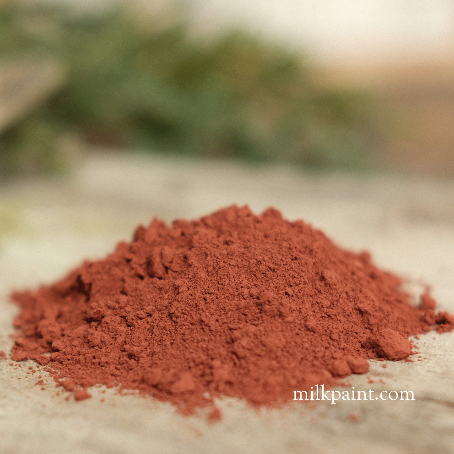 Red powder on a textured surface with a blurred natural background