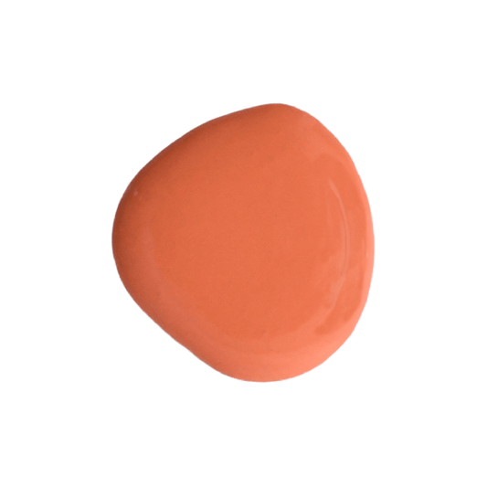A dollop of Sweet Pickins milk paint in the orange color Completely Coral, up against a white background.