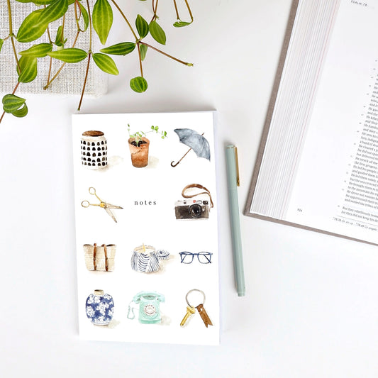 Notebook with illustrations of daily objects on a white surface.