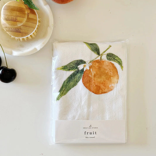 Packaged tea towel with orange design on a white surface