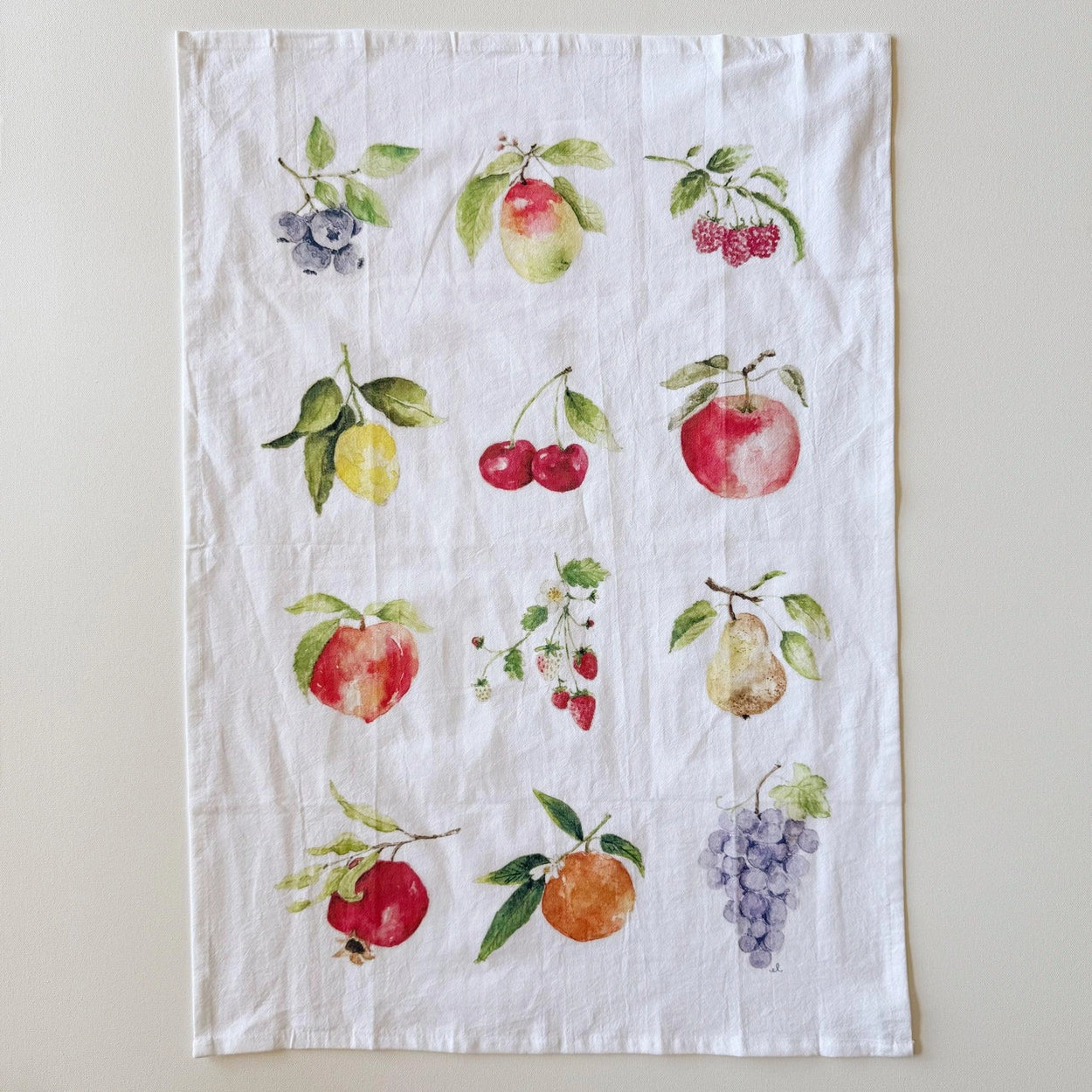 Tea towel with fruit illustrations on a white background