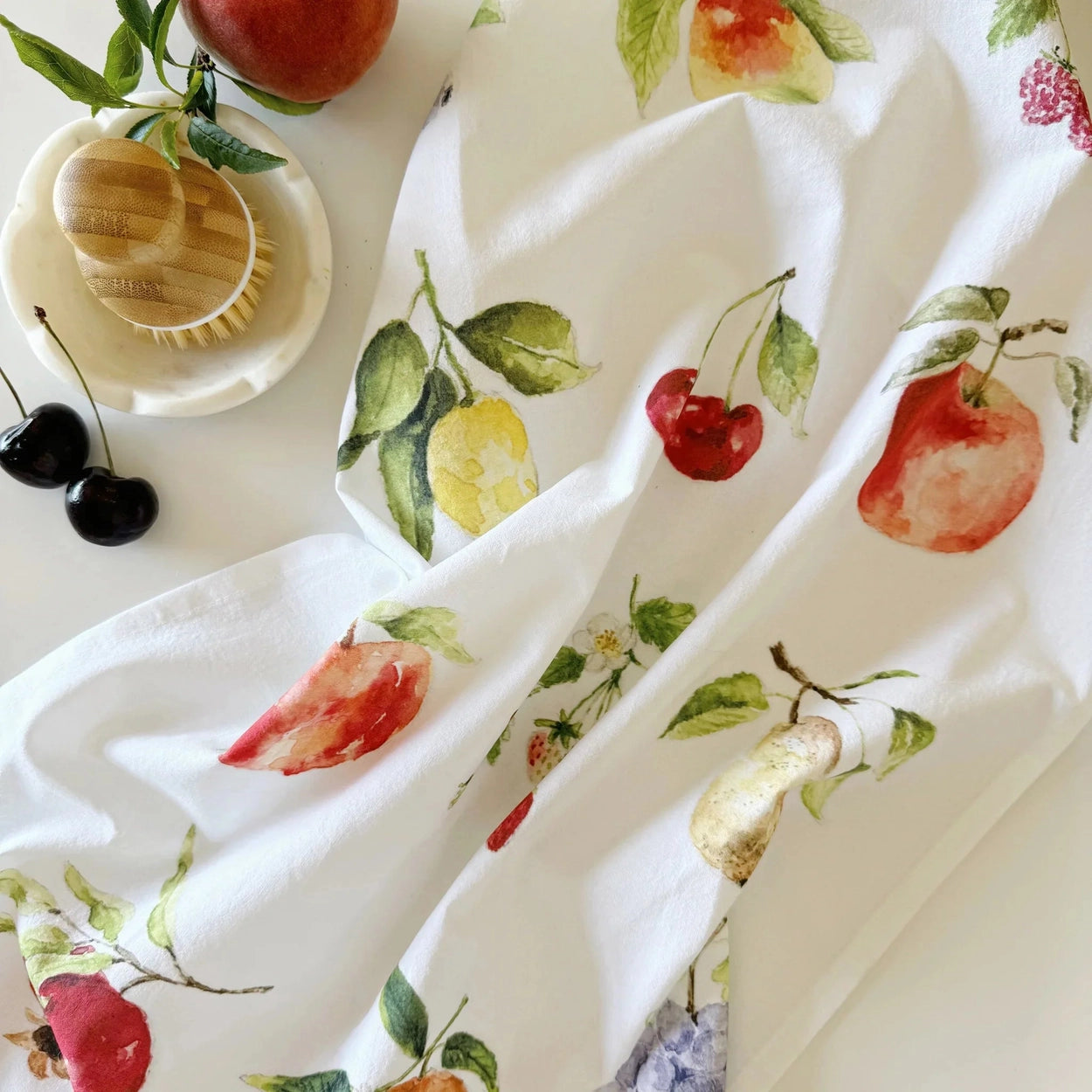 White fabric with colorful fruit pattern on a white background