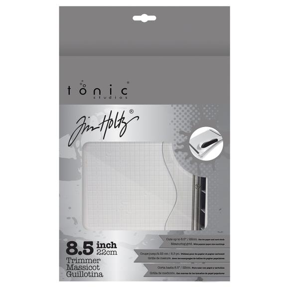 Tonic Studios and Jim Holtz trimmer packaging with a white trimmer inside