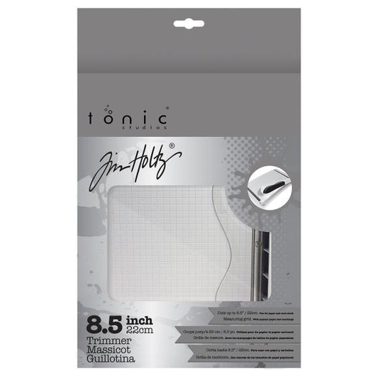 Tonic Studios and Jim Holtz trimmer packaging with a white trimmer inside