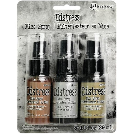 Three bottles of Ranger Distress Mica Spray on packaging with a textured background