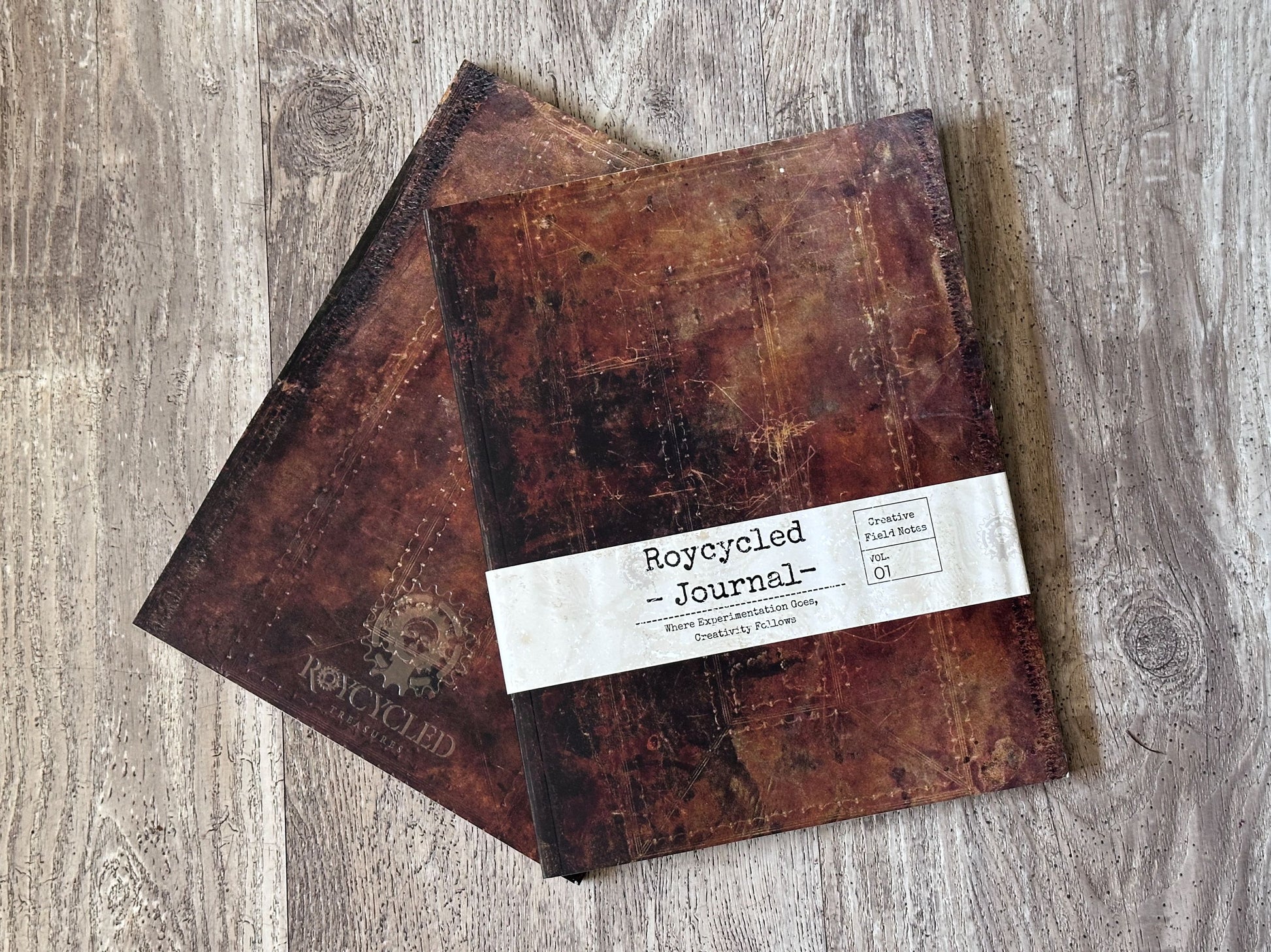 Two brown journals with a label on a wooden surface