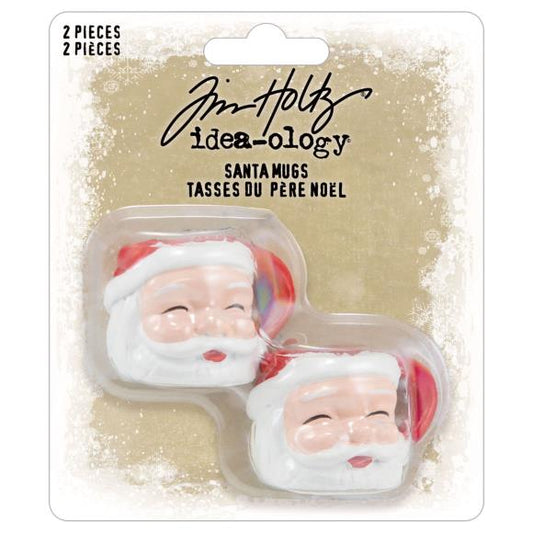 Two Santa Claus mugs in packaging with Tim Holtz Idea-ology branding on a beige background.