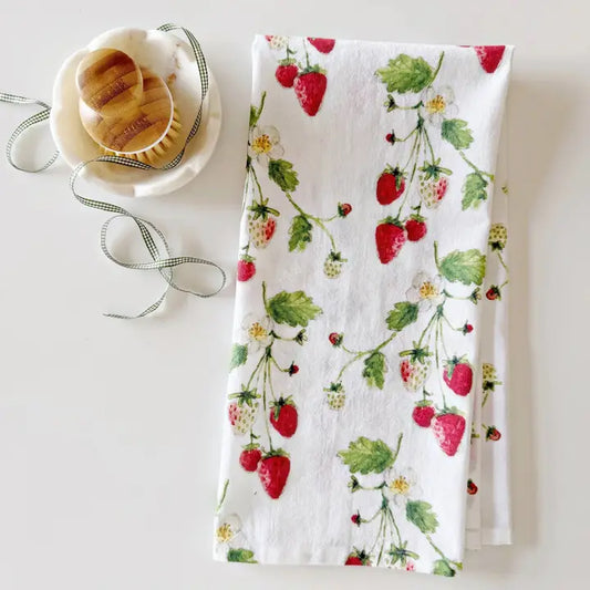 Strawberry-patterned tea towel on a white surface.