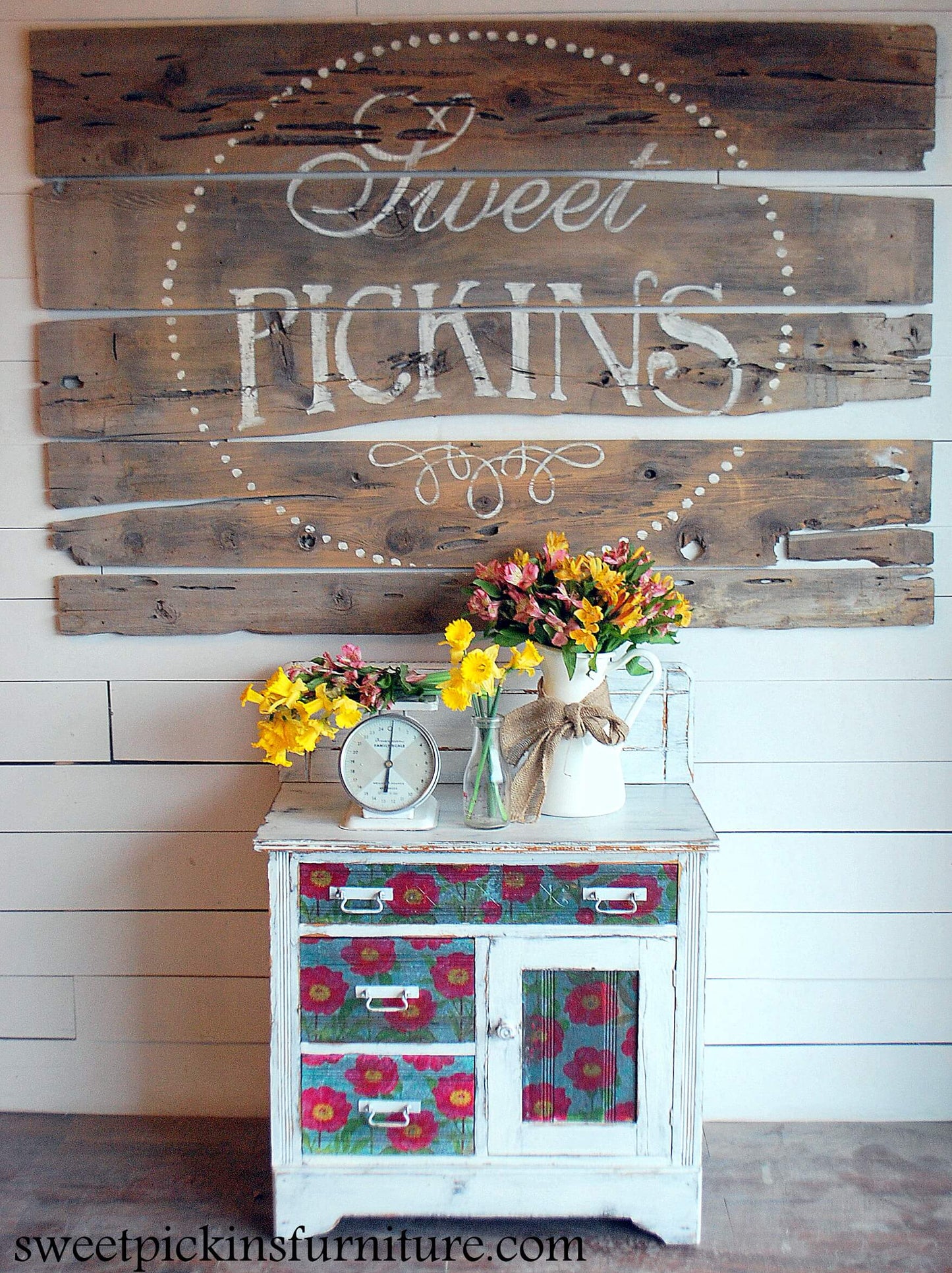 A nightstand painted white in the shade Window Pane, with added flowers for artistic effect and a "Sweet Pickins" sign behind it.