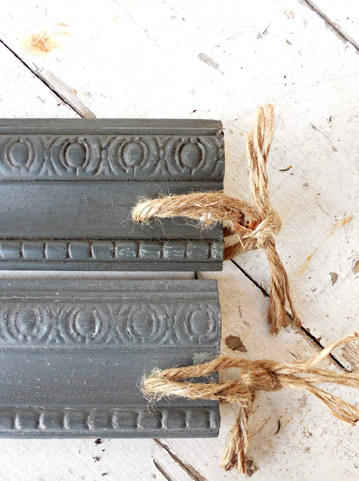 Decorative gray molding milk painted in color 'Zinc' with intricate patterns on a light wooden surface.