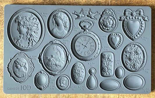A gray-colored mold with various designs including cameos and jewelry-like shapes.