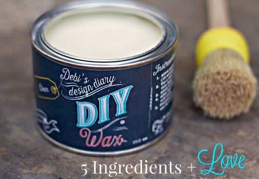 An open can of clear furniture wax with a label reading "Debi's Design Diary DIY Wax", with a brush laying beside it and a text that reads "5 ingredients + Love".